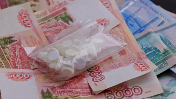 Looped Rotation of Russian Rubles Paper Banknotes and Ziplock Plastic Bag with White Capsules