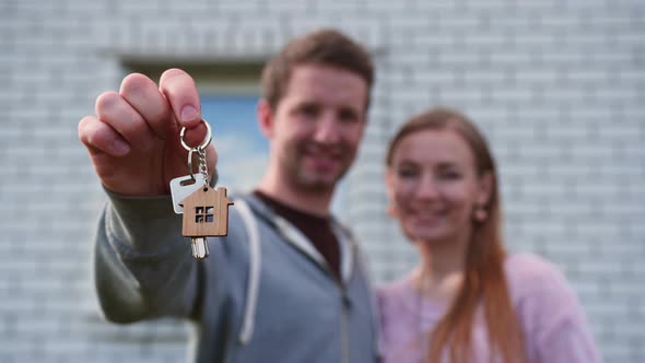 Real Estate Purchase Concept. Young Spouses Show Off Keys To the Purchased New Home. alt
