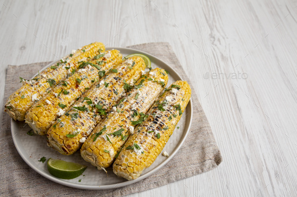 Homemade Elote Mexican Street Corn on a plate, side view. Space for ...