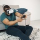 Black guy with virtual reality glasses sitting on a carpet in living room - PhotoDune Item for Sale