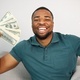 Black guy sitting on a couch in living room holding a cash - PhotoDune Item for Sale