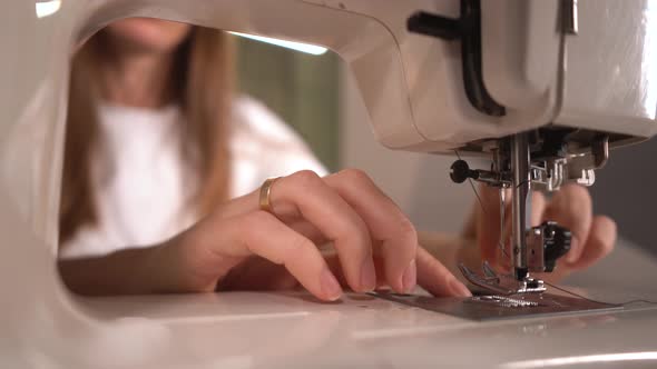  Woman Inserts a Bobbin Into a Sewing Machine