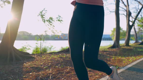 Asian young beautiful sport woman running on street in public park. alt