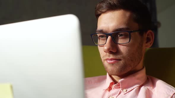 Closeup Face of Focused Business Man in Glasses Looking at Laptop Screen Working on Computer Sitting alt