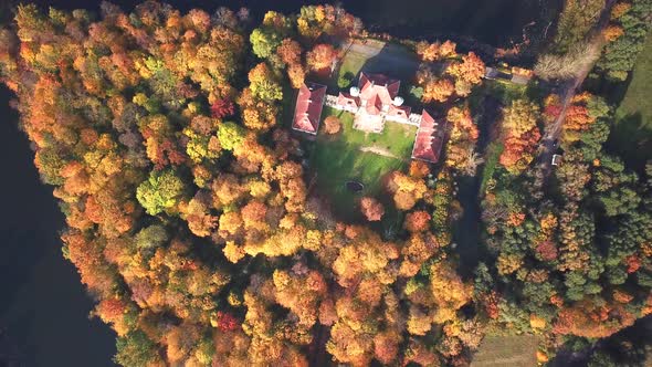 AERIAL zoom out of Castle. Flight over beautiful castle; located in landscape park with green trees alt