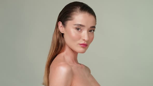 Beautiful Young Woman with Clean Fresh Skin Standing Over Light Grey Background alt