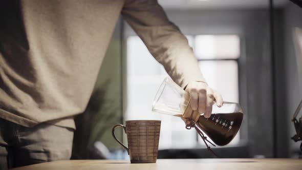 Make Chemex coffe in office. Brewing Pour Over Style of Coffee. Chemex. Barista makes cof