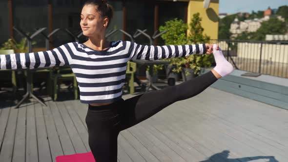 Woman Doing Yoga Exercises on House Roof in Early Morning alt