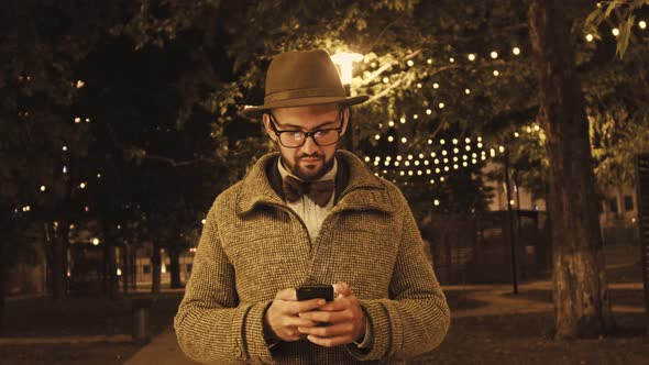 Arab Man Browsing Smartphone on Street alt