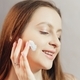 Young smiling woman is applying cream to her cheeks - PhotoDune Item for Sale
