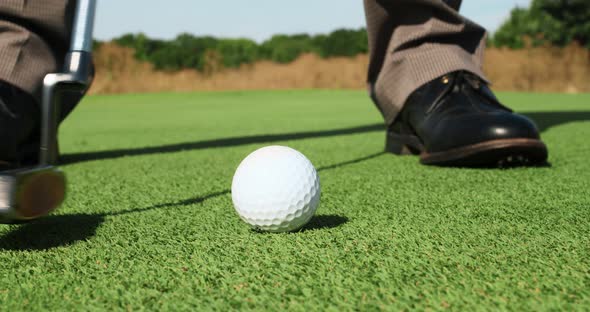Close Up of Professional Male Player Hitting Ball with Golf Club Practicing Playing Golf Outdoors alt