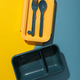 A blue lunchbox with a yellow lid and blue forks - PhotoDune Item for Sale