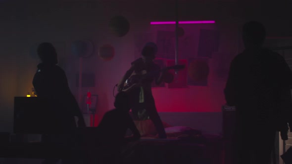 Teenager Playing Guitar for Family at Night alt