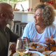 Smiling Senior Couple Enjoying Meal At Home Together And Drinking Glasses Of Wine - PhotoDune Item for Sale
