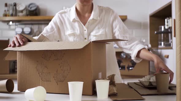 The Girl Collects And Folds Cardboard Paper Garbage For Recycling In A Special Box With The Sign alt