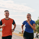 A couple dressed in sportswear runs along a scenic road during an early morning workout, enjoying - PhotoDune Item for Sale