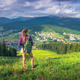 Girl on the hill with yellow flowers and green grass in mountains - PhotoDune Item for Sale