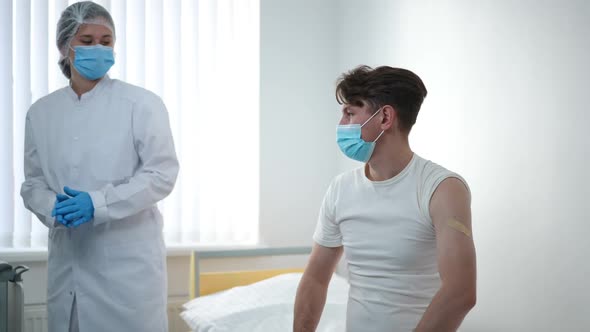 Satisfied Patient Shaking Hands with Doctor After Coronavirus Vaccination in Hospital alt