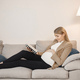Pregnant lady lie on a sofa in living room and reading a book - PhotoDune Item for Sale
