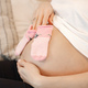 Midsection of pregnant lady lie on a bed and holding a little baby socks - PhotoDune Item for Sale