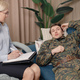 Soldier in military uniform talking to psychiatrist at therapy session - PhotoDune Item for Sale