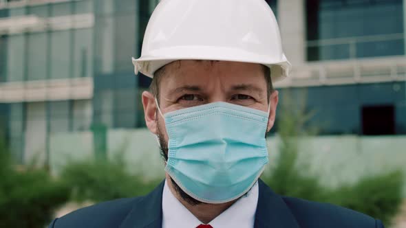 Close Up Portrait Senior Engineer Wearing a White Safety Helmet with a Beard a Business Suit and a alt