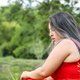 woman looking down at the ground with a worried face, sitting with a forest in the background. - PhotoDune Item for Sale