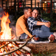 young Latin peasant couple, sitting by a campfire at night, embracing and giving each other love. - PhotoDune Item for Sale