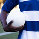 African American young male athlete holding a rugby ball, ready to play on the field outdoors - PhotoDune Item for Sale