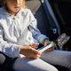 Young Girl Engrossed in Using a Smartphone While Sitting in a Car on a Sunny Day - PhotoDune Item for Sale