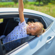 Young Girl Joyfully Waving Hand Out of Car Window on Sunny Day - PhotoDune Item for Sale