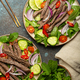 Two plates with traditional Thai beef salad with vegetables and mint top view served on rustic - PhotoDune Item for Sale