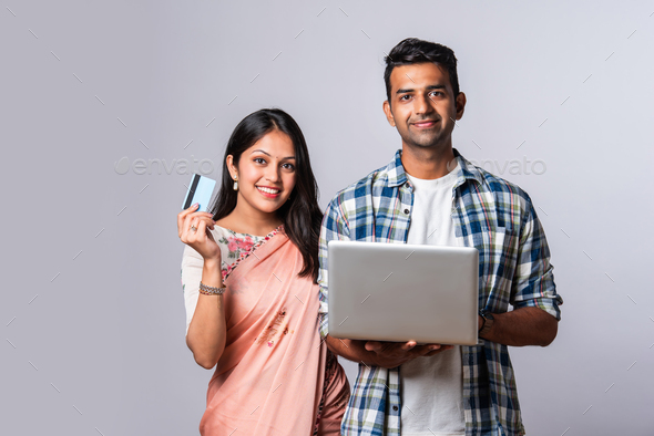 Attractive Indian asian young couple holding their laptop on white ...