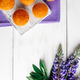 Delicious muffins and purple lupine flowers on white wooden background. - PhotoDune Item for Sale