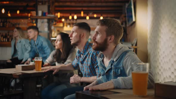A Group of Men and Women in a Pub Together Cheer for Their National Team at the World Cup in alt