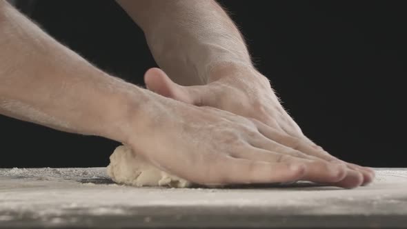 Male Hands Divide Baking Dough Into Shares on a Board Sprinkled with Flour alt