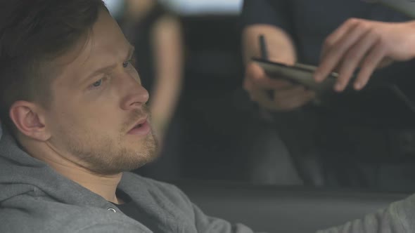 Sad Man in Car Receiving Parking Ticket From Police Officer, Traffic Violation alt