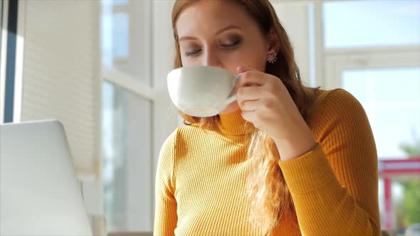 Beautiful Sunny Day Young Woman Drinks Morning Coffee in a Cafe, Making Online a Purchase Easy alt