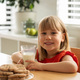 Cheerful girl enjoying fresh milk and homemade cookies, perfect for a wholesome snack time. - PhotoDune Item for Sale