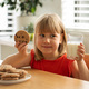Cheerful girl with a cookie and milk, enjoying a sweet snack at home. - PhotoDune Item for Sale