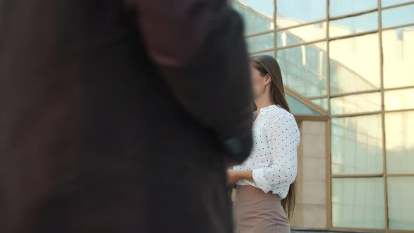 Slow Motion of Serious Businessman and Businesswoman Talking Standing Near Office Building alt