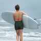 Rear view of female surfer on summer beach carrying her board, sports training during beach holiday - PhotoDune Item for Sale