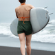 Rear view of unrecognizable woman surfer walking on sand beach with surfboard in hand - PhotoDune Item for Sale