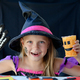 A little girl in a witch costume looks at the camera and laughs,  - PhotoDune Item for Sale