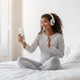Smiling Young Woman With Headphones Video Calling From Bright Bedroom - PhotoDune Item for Sale
