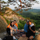 happy friends eating pizza at the cliff with beautiful mountain view - PhotoDune Item for Sale