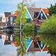 A picturesque scene showing a row of charming houses nestled next to a tranquil body of water - PhotoDune Item for Sale