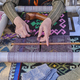 Hands of senior woman weaves a carpet with traditional asian pattern on handloom - PhotoDune Item for Sale