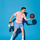 Dynamic Hoopster: Young Man With Basketball Against Blue - PhotoDune Item for Sale
