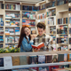 Young couple enjoys exploring books in a cozy library - PhotoDune Item for Sale